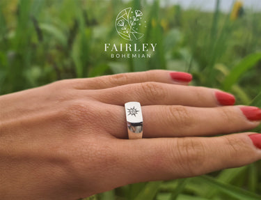 man made lab grown diamond set in sterling silver signet ringhand model red nail polish in field